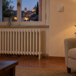 Soggiorno con radiatore integro e termostato a parete durante una normale serata domestica