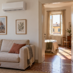 Soggiorno con climatizzatore e porta aperta verso una camera adiacente illuminata dal sole
